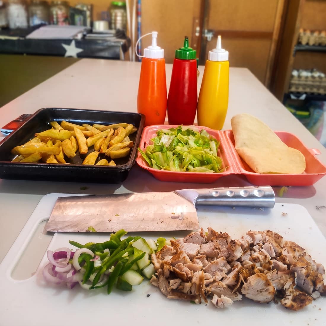 Prepping fresh shawarma, fries, and salads in the Queso Pizza kitchen